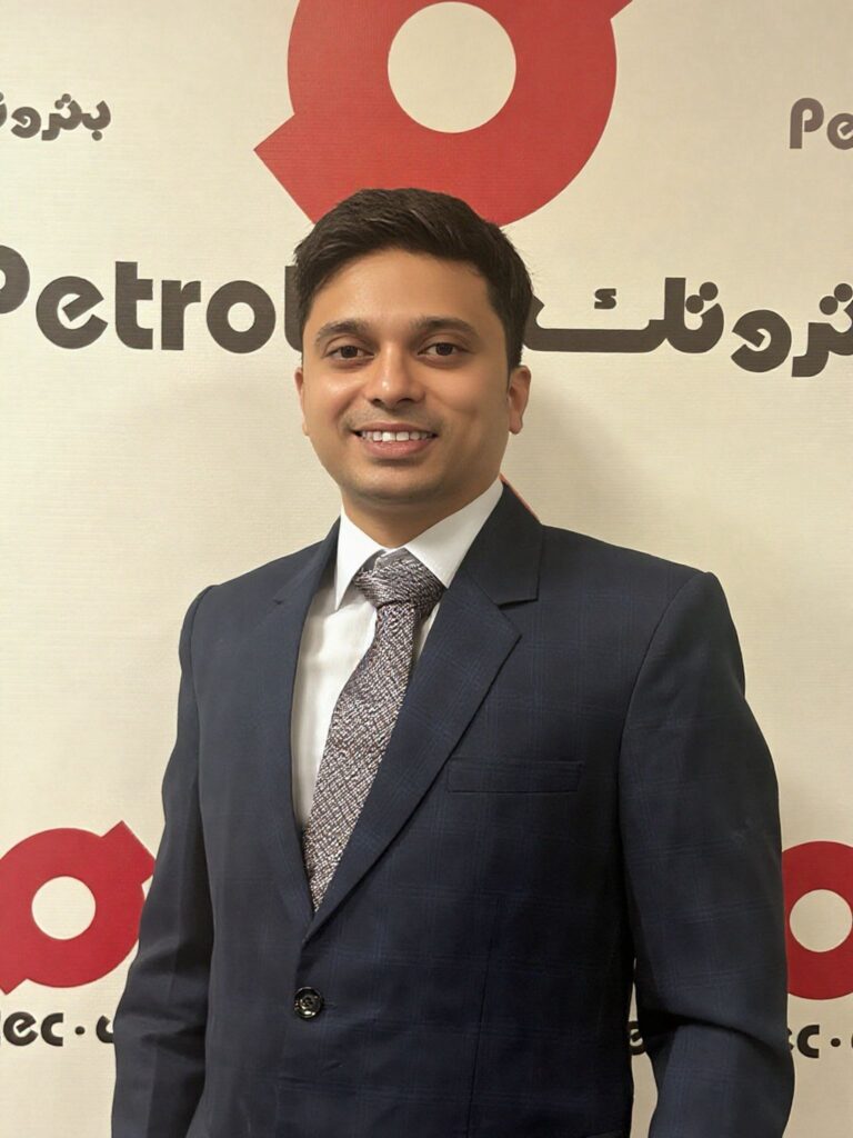 Man in suit against logo backdrop.