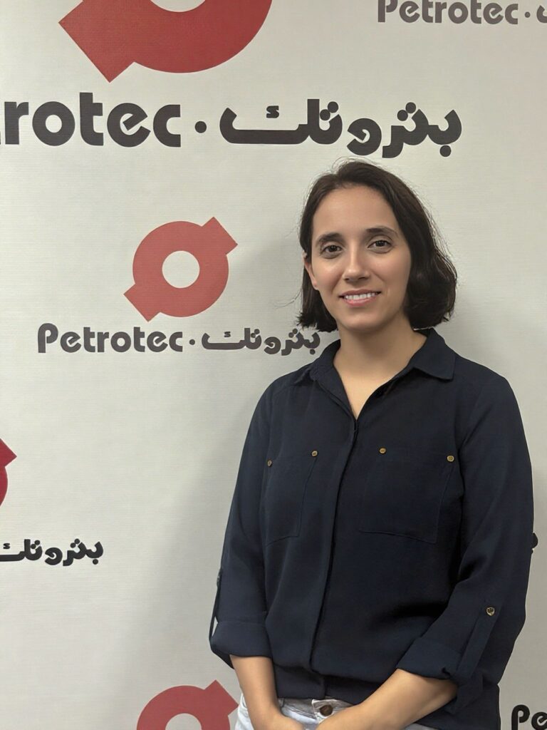 Person standing against a logo backdrop.